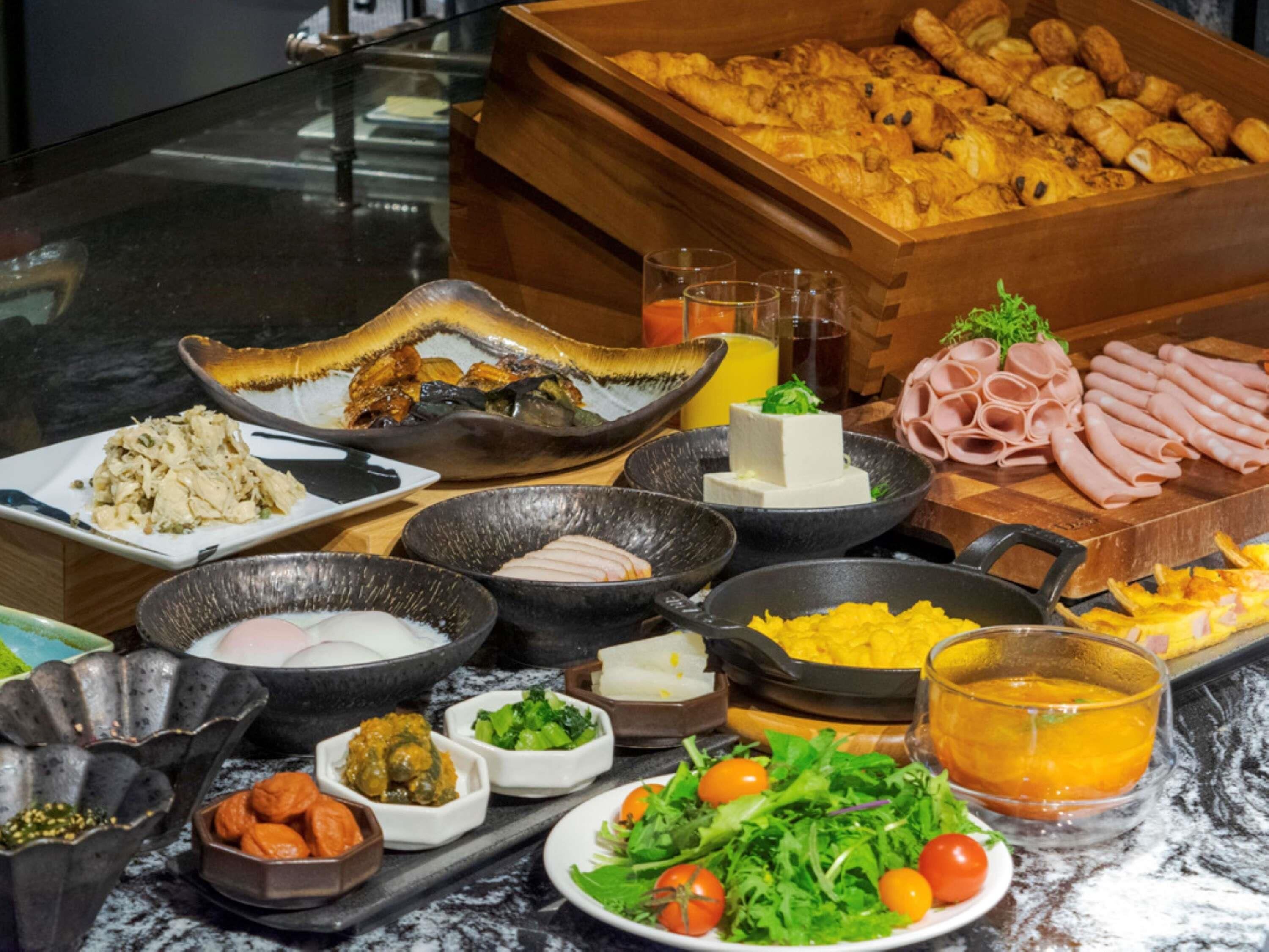 Un bufé con diversas opciones de comida, como carnes, quesos y verduras.