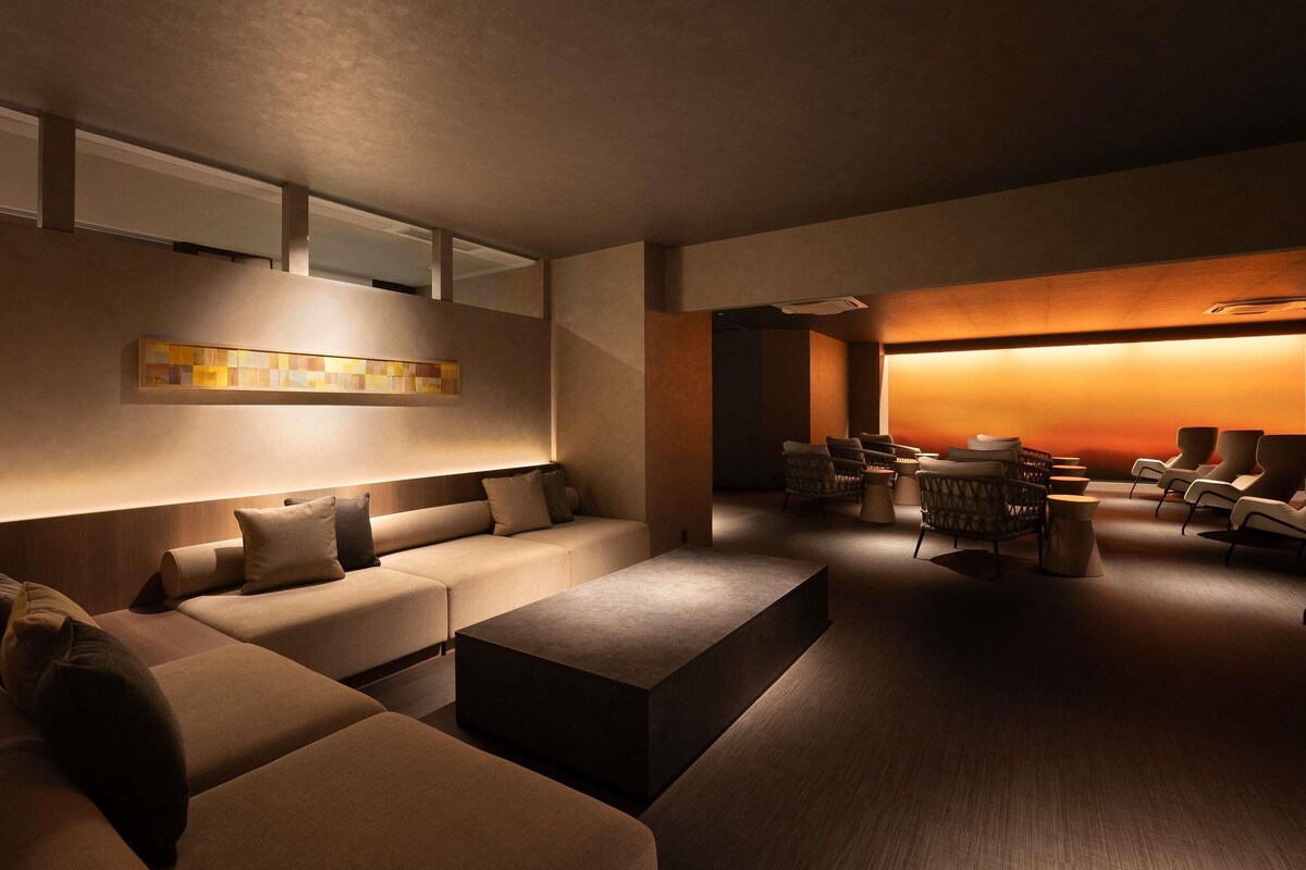 A modern lounge area with a sofa set, a coffee table, and a seating area with chairs.