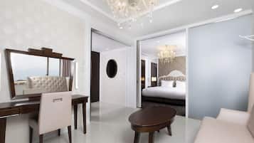 Une chambre d’hôtel moderne dotée d’un grand lit, d’un coin salon avec un canapé et une petite table, d’un bureau avec une chaise et d’un grand miroir.