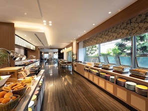 A buffet area with food displays, seating, and a view of greenery outside. - Grand Mercure Nara Kashihara (Kashihara)