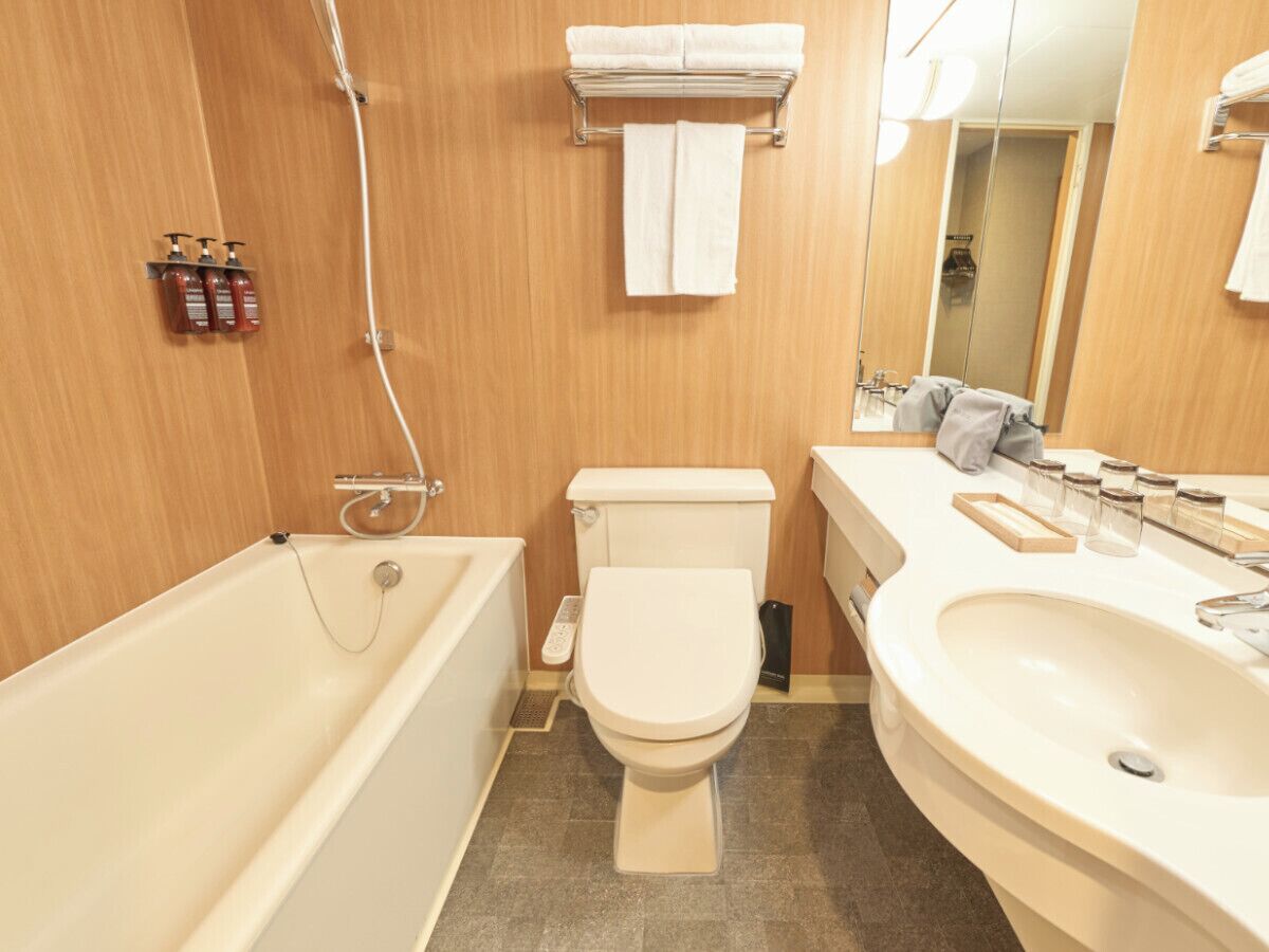 Ein Badezimmer mit Badewanne, Toilette, Waschbecken und Spiegel.
