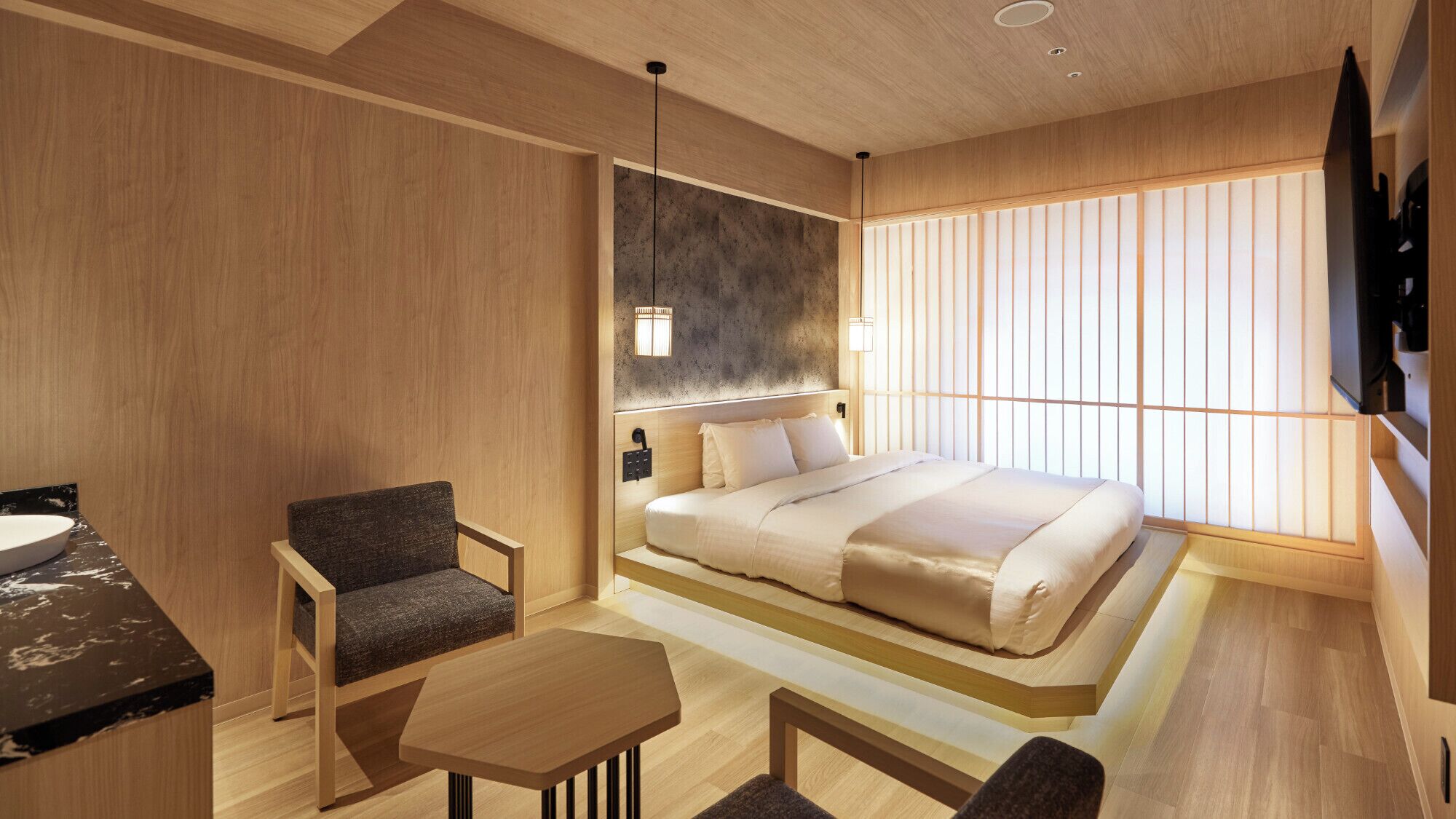 A modern hotel room with a bed, a desk, a chair, and a TV.