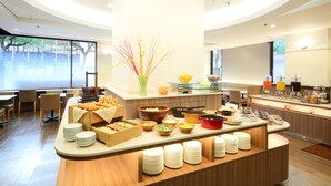 A modern breakfast buffet with various food items and a central decorative vase. - Takamatsu Tokyu REI Hotel (Takamatsu)