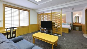 A hotel room with a sofa, a yellow bench, a TV, a bed, and a partition with a lattice design. - Rihga Hotel Zest Takamatsu (Takamatsu)