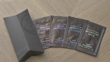 Cuatro paquetes de productos cosméticos sobre una superficie de madera.
