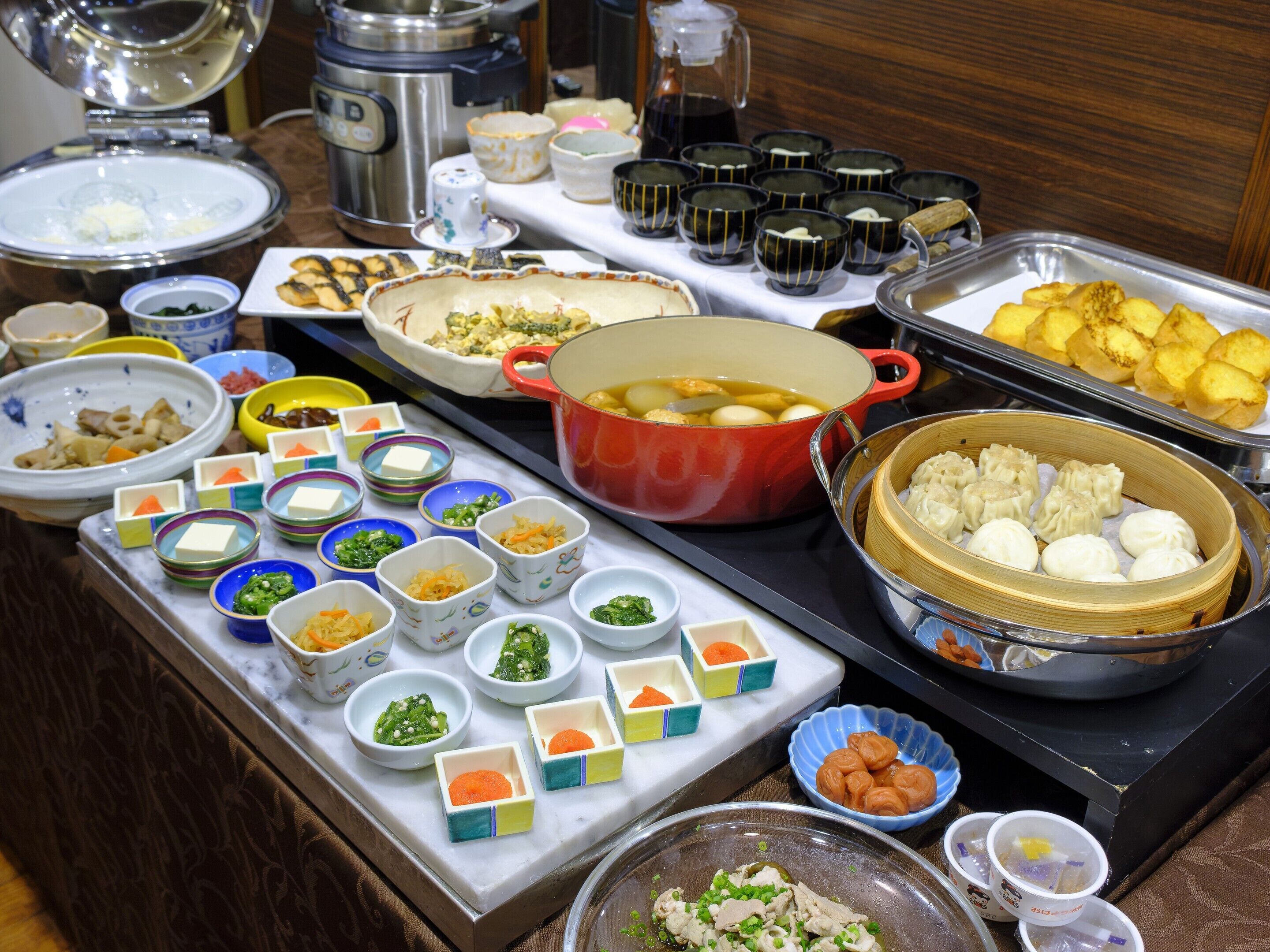 A buffet with various dishes and food items.