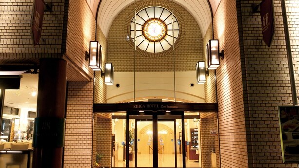 A hotel entrance with a brick facade, a circular skylight, and a red carpet leading to the doors. - Rihga Hotel Zest Takamatsu (Takamatsu)