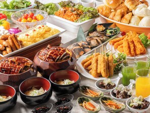 Un assortiment de plats comprenant des sushis, des sashimis et des plats panés, ainsi que de petits bols de condiments et de boissons.