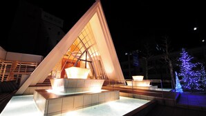 Una estructura arquitectónica moderna con diseño triangular e interior iluminado.