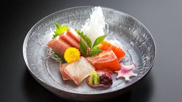 Een bord sushi met verschillende soorten vis en garneringen.