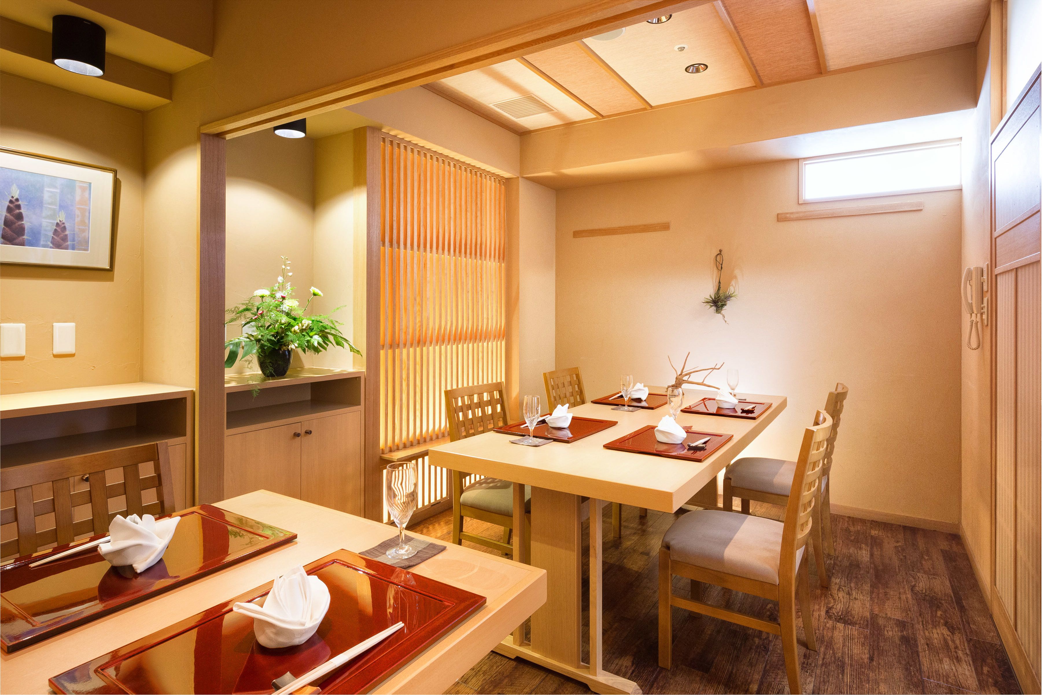 A traditional Japanese-style dining room with wooden furniture, a low table, and a sliding door.