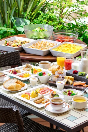 A breakfast buffet with various dishes, beverages, and a wicker chair. - Hotel Kokusai 21 Nagano (Nagano)