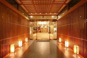 A hotel lobby with a wooden reception desk, a reception area, and a check-in counter. - Hotel Obana (Nara)