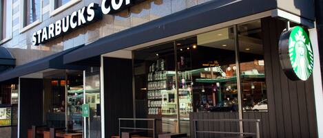 Een Starbucks Coffee winkel met terras en een helder zicht op het interieur door de glazen pui.