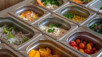 A buffet with various food items including fruits, vegetables, and salads.