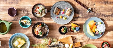 A variety of dishes and a newspaper on a wooden table.