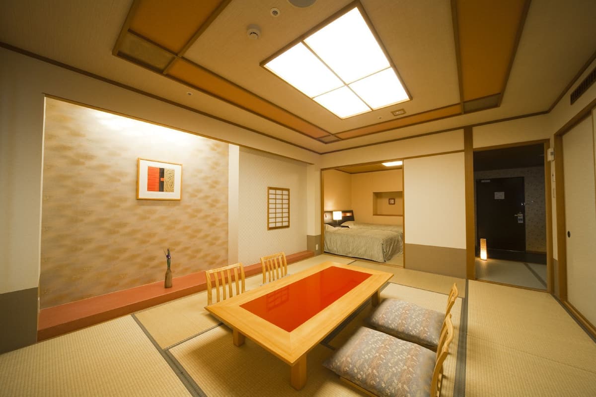 Una habitación japonesa tradicional con suelo de tatami, una mesa de madera baja y un futón.
