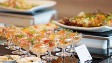 A buffet with various dishes, including a salad and a dish with smoked salmon.