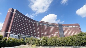 A large, modern hotel with a curved facade and multiple windows.
