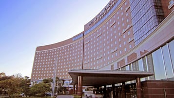 Un edificio hotelero grande y curvo, con una entrada destacada y un área techada.