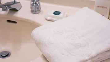 A bathroom sink with a towel and a soap dispenser.