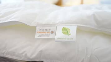 Un oreiller blanc muni d’une étiquette indiquant qu’il est certifié OEKO-TEX STANDARD 100, ce qui suggère qu’il est fabriqué à partir de matériaux sans danger.