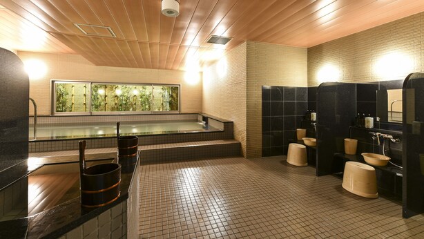 A modern bathroom with a large bathtub, multiple sinks, and a wooden ceiling.