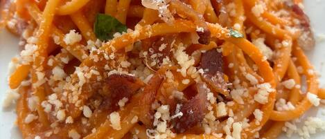 Ein Teller Spaghetti mit Speck und Käse.