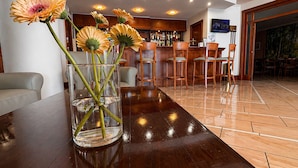 Een bar met krukken, een toog en een aan de muur bevestigde televisie.