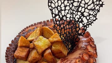 A plate with octopus, potatoes, and a decorative element.
