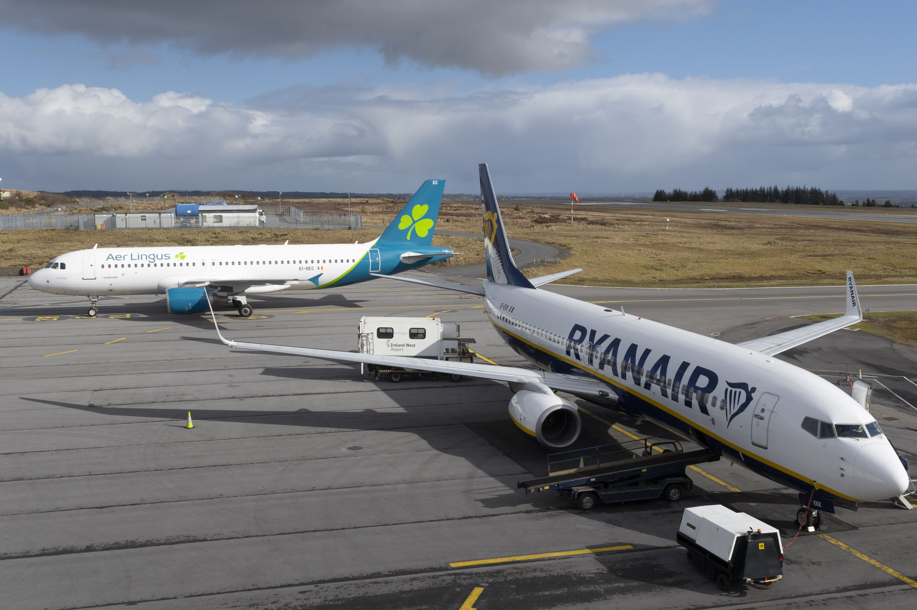 Three airplanes parked at an airport.