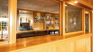 Zona de bar con mostradores de madera, estantes llenos de botellas de licores y un jukebox.