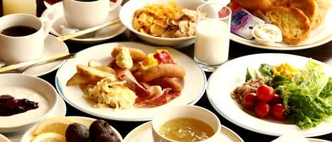 A breakfast table with various dishes including eggs, bacon, toast, cereal, and fruits.