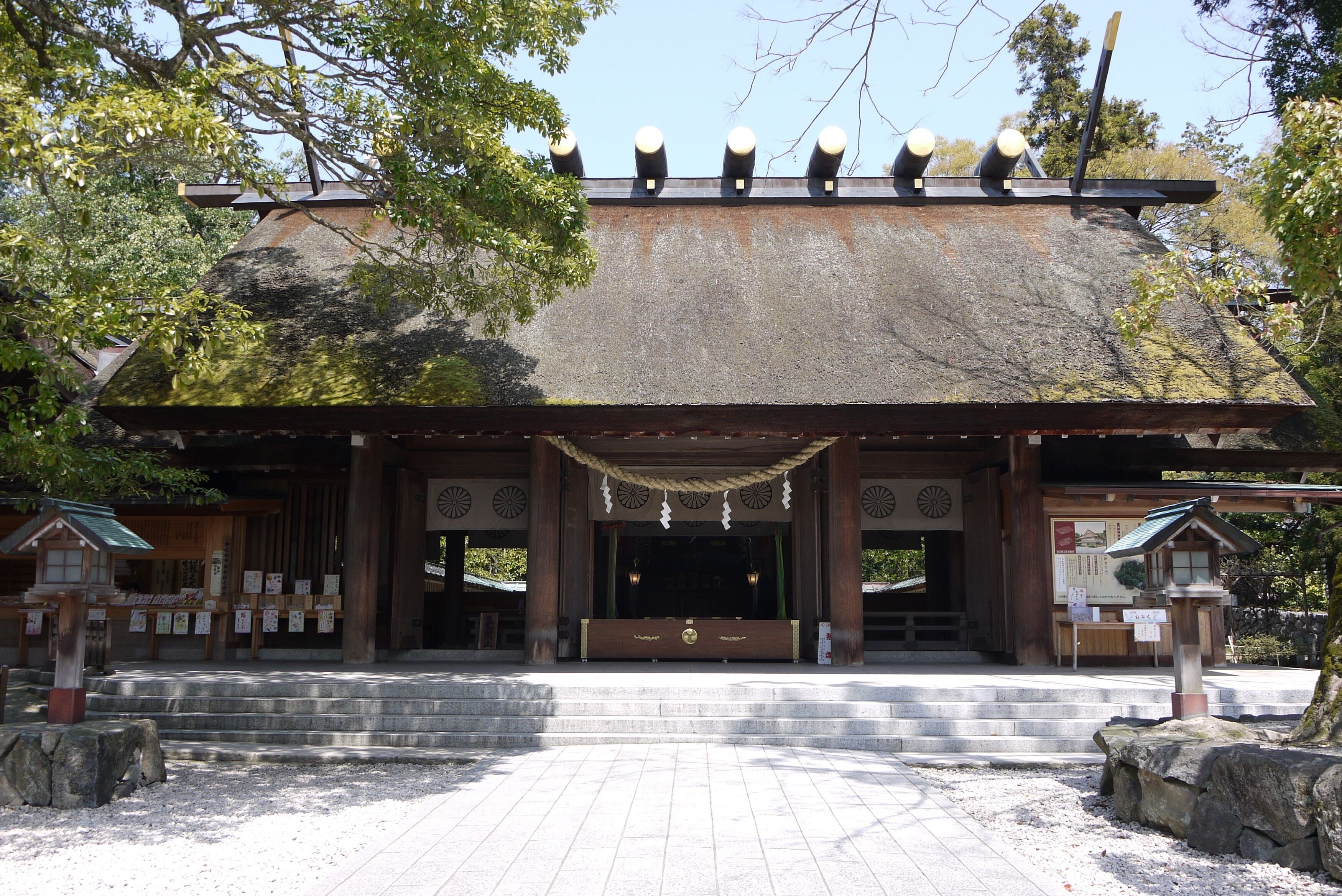 En traditionell japansk byggnad med ett tak täckt av tegelpannor, träbjälkar och en stentrappa som leder upp till entrén.