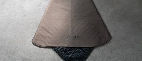 Une couverture de lit pliée, sur laquelle on peut lire le texte « MERCURE HOTELS ».