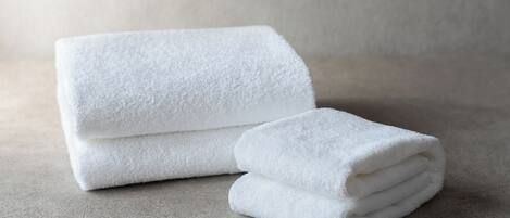 A stack of white towels on a textured surface.