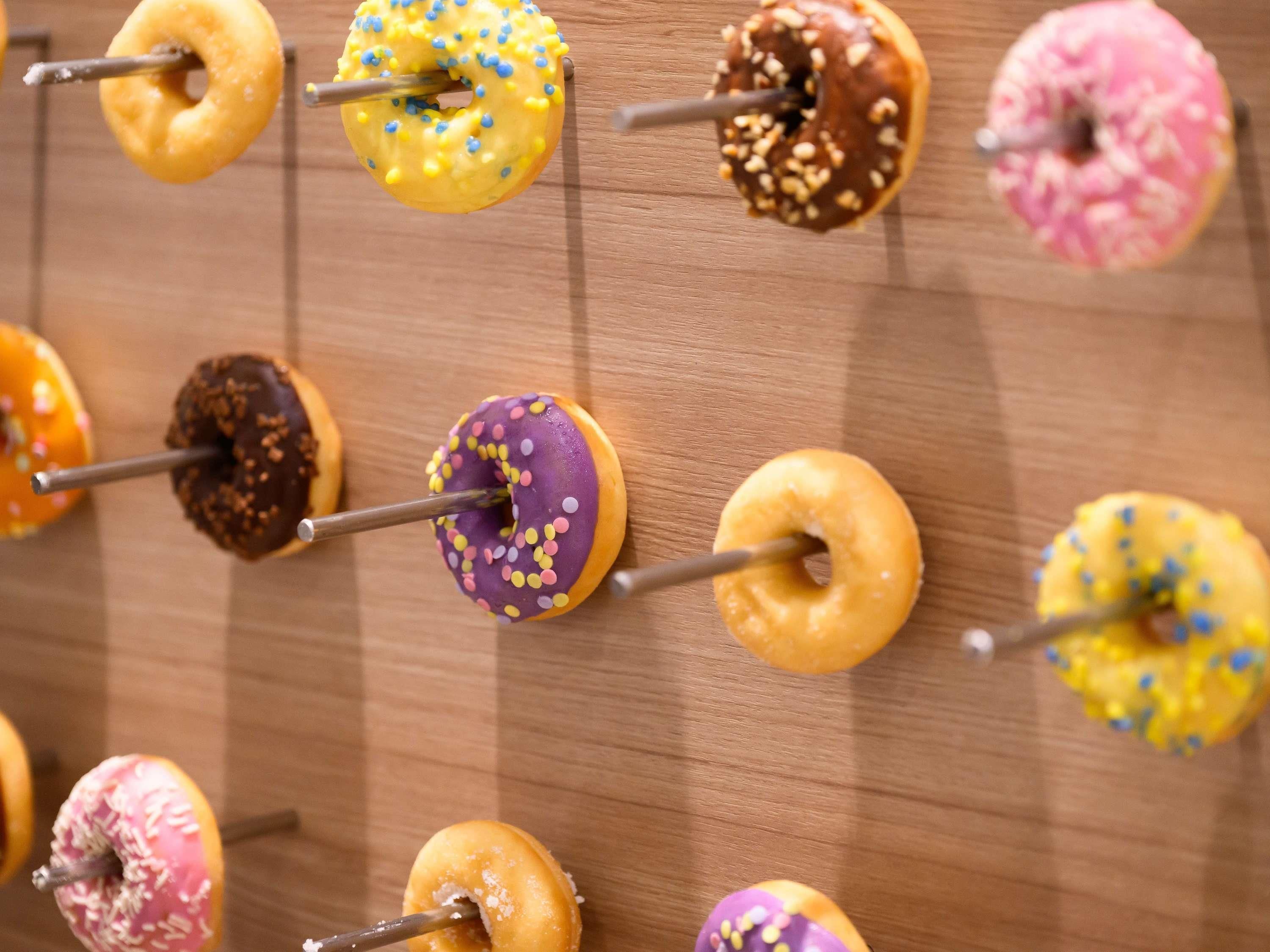 Una superficie de madera con varios donuts dispuestos en forma de cuadrícula.
