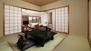 A tatami mat room with a tatami mat table, a futon bed, and sliding doors. - Mercure Kyoto Miyazu Resort & Spa (Miyazu)