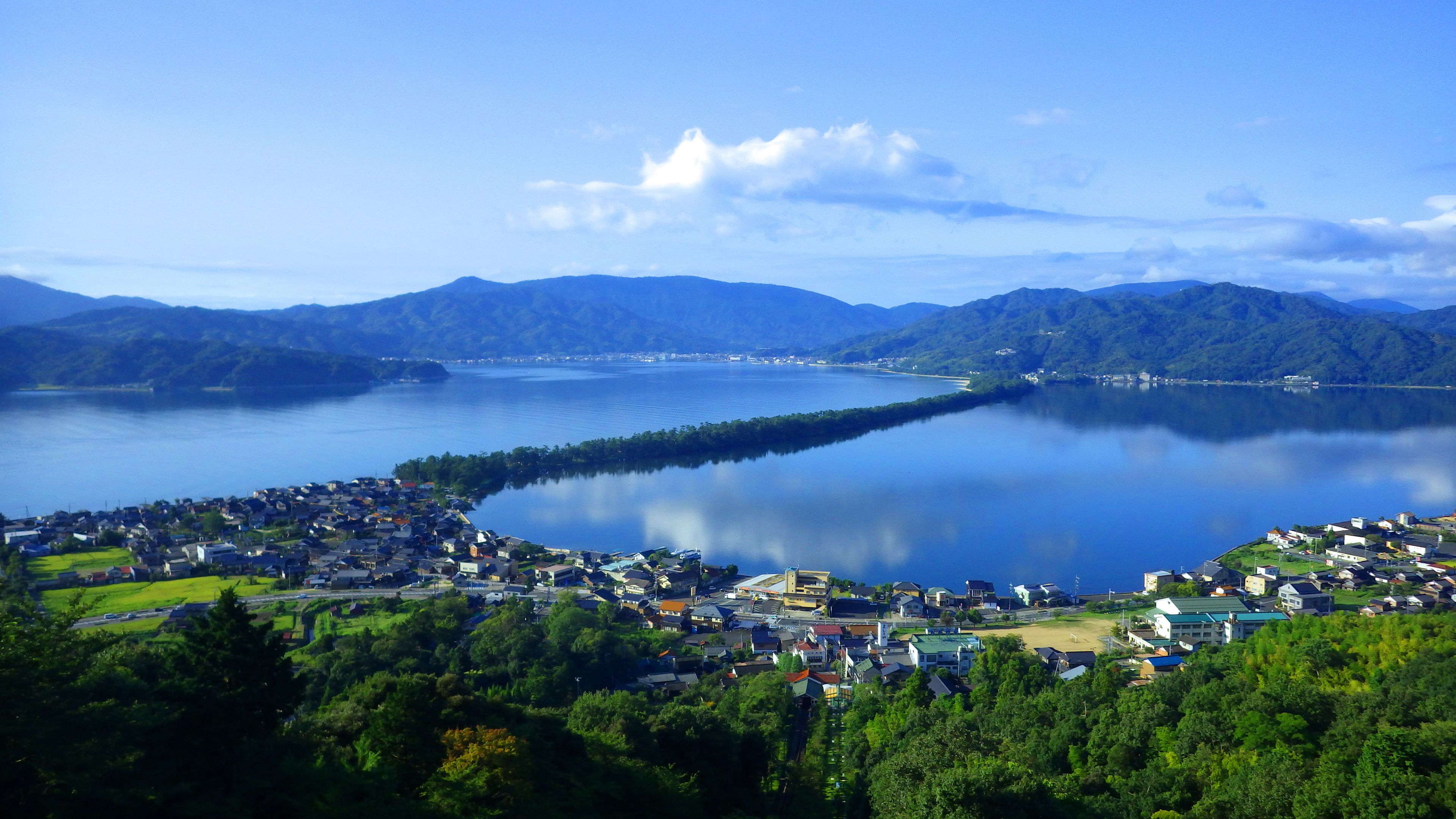 A lakeside town with a view of mountains in the background.