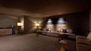 A dimly lit room with a sofa, two lamps, and a wall-mounted light fixture.