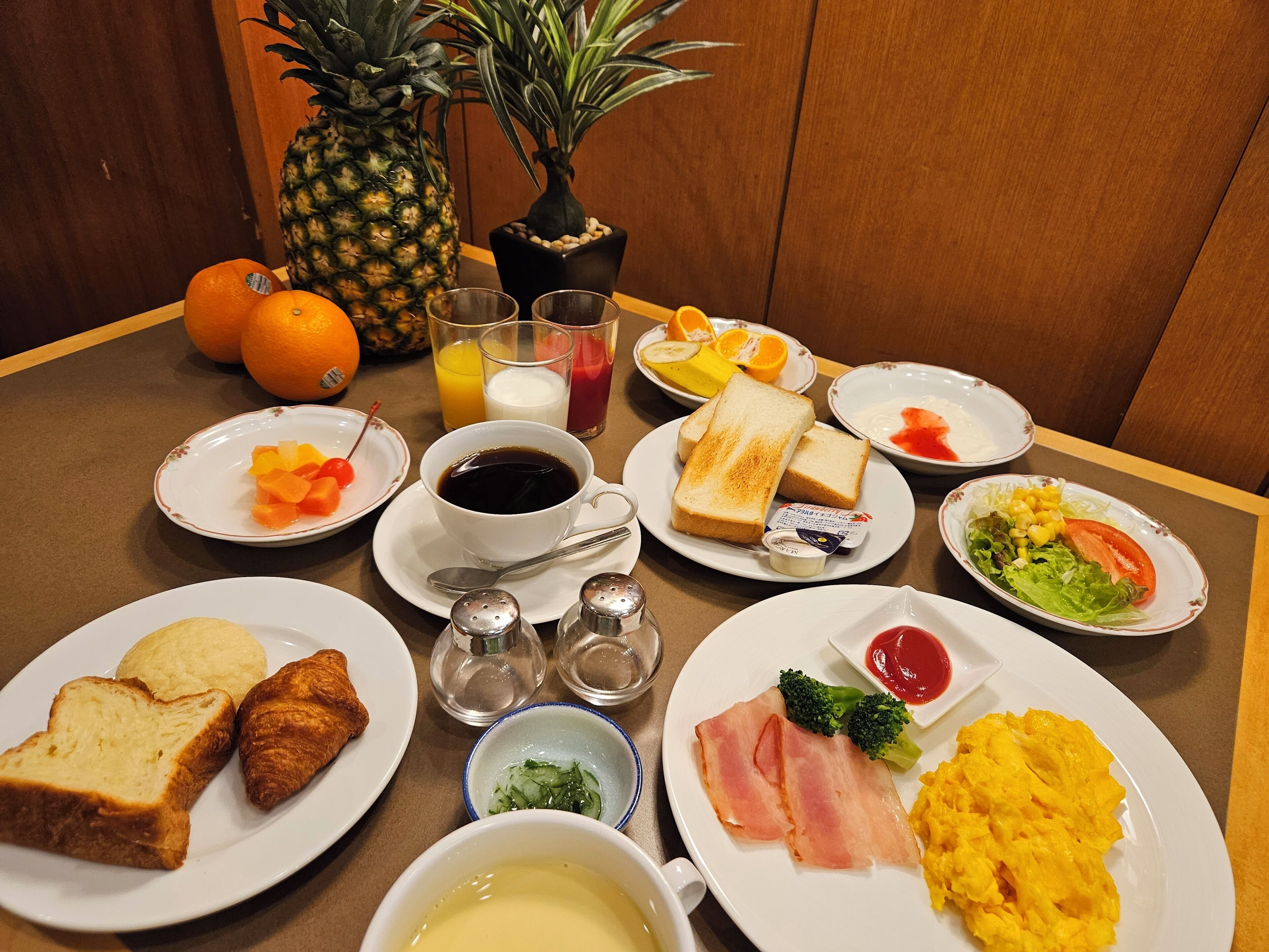 A breakfast table with various dishes including toast, eggs, and fruit.