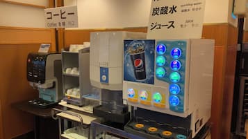 A coffee machine and a beverage dispenser with multiple drink options, including Pepsi.
