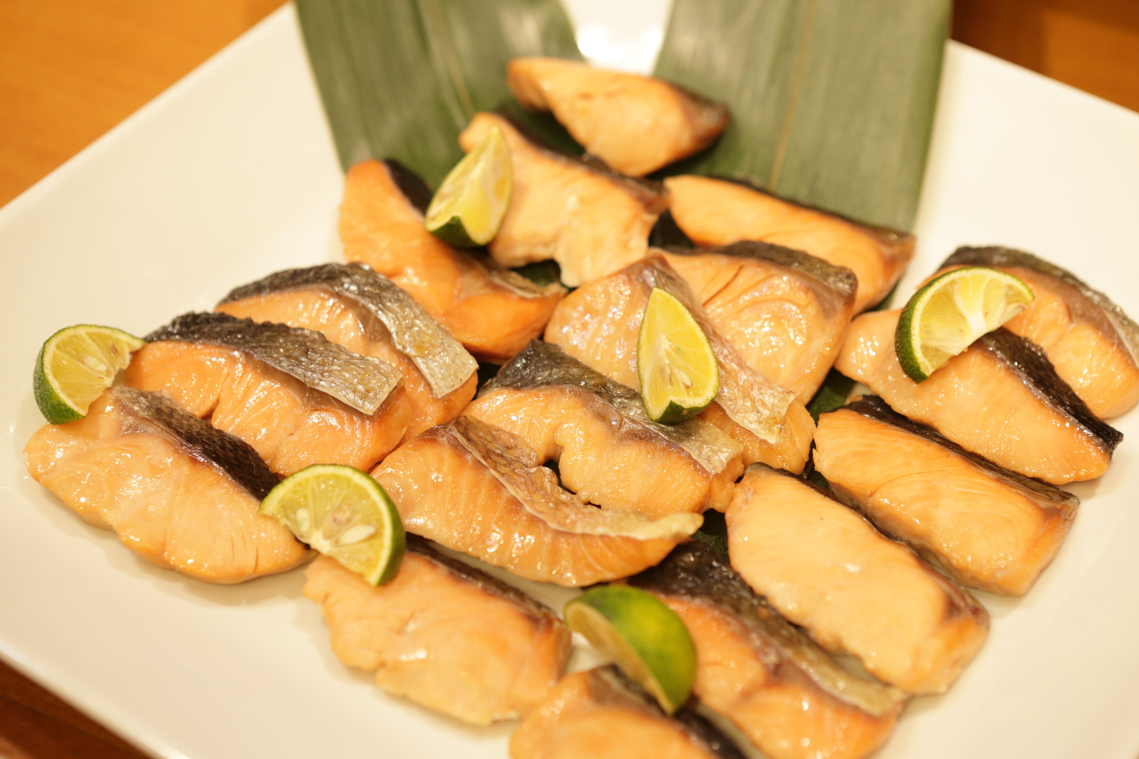 A plate of cooked fish garnished with lime slices.