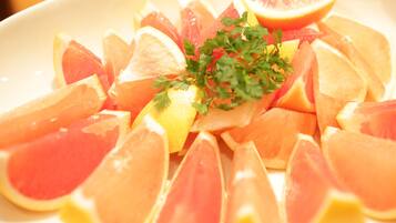 A plate of sliced citrus fruits, including oranges and grapefruits, garnished with parsley.