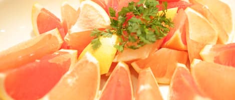 Un plato de frutas cítricas en rodajas, como naranjas y pomelos, adornado con perejil.