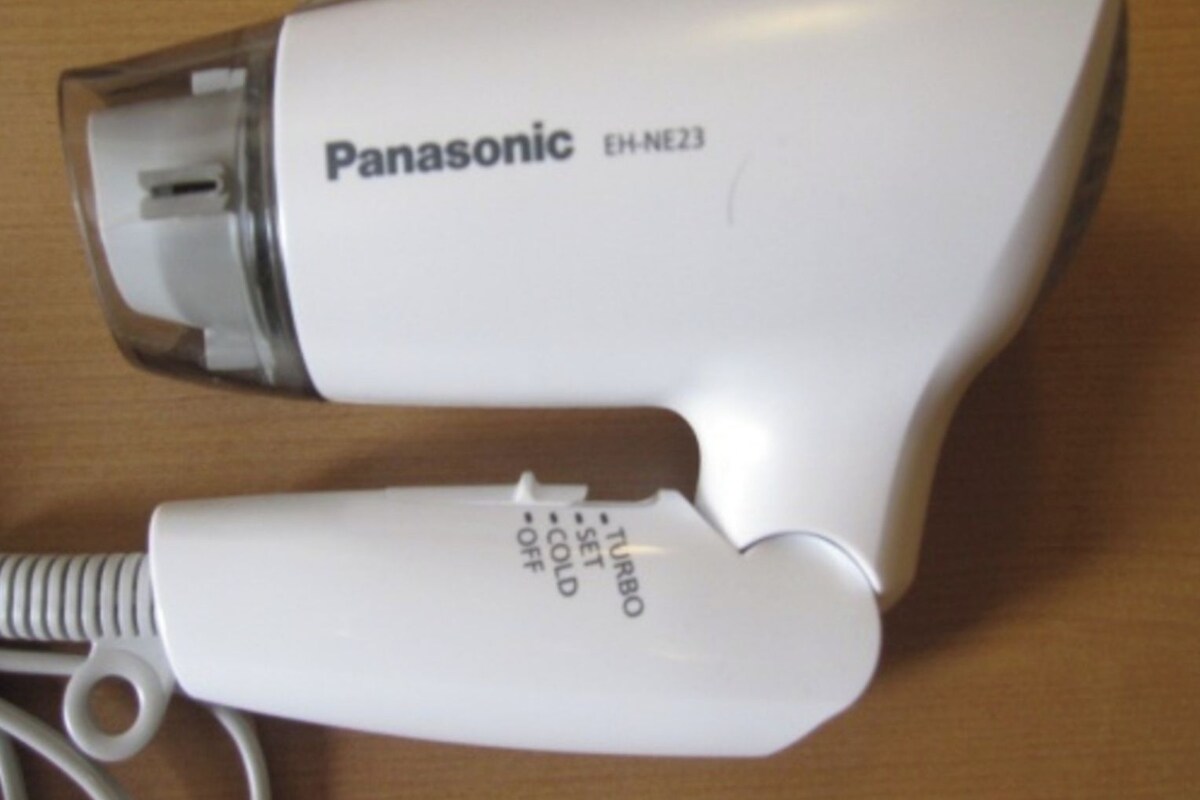 A Panasonic EH-NE23 hair dryer on a wooden surface.