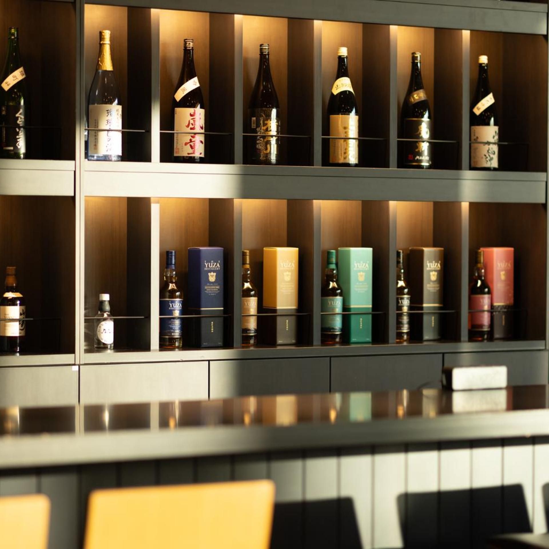 A bar area with shelves of various liquor bottles and boxes.