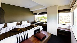 A modern hotel room with a large bed, a desk, and a window offering a city view. - Tsukino Hotel (Sakata)
