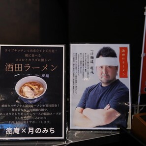 A menu board with Japanese text and a photo of a man with crossed arms. - Tsukino Hotel (Sakata)