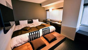 A modern bedroom with a bed, bedside tables, a desk, and a window.